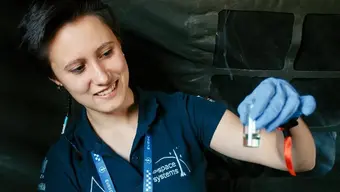 Zdjęcie przedstawia młoda kobietę, członkini Koła Naukowego AGH Space Systems.