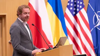 Zdjęcie przedstawia Davida van Weel przy mównicy, przemawia podczas forum