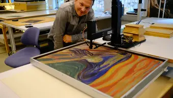 Image of Dr Łojewski in a laboratory at a table with a specialised device working on The Scream painting