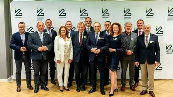 Grupowe zdjęcie kilkunastu osób - uczestników i uczestniczek konferencji. Wśród nich Rektor Jerzy Lis.