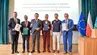 Zdjęcie grupowe: rektorzy uczelni z podpisanymi dokumentami stoją obok siebie na scenie. Razem z nimi Sławosz Uznański-Wiśniewski.