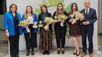 Na zdjęciu cztery laureatki z AGH oraz dr hab. inż. Katarzyna Styszko, prof. AGH i dr hab. inż. Marek Jaszczur, prof. AGH. Stoją obok siebie w rzędzie. Laureatki pośrodku trzymaja w dłoniach bukiety kwiatów oraz pamiątkowe statuetki.