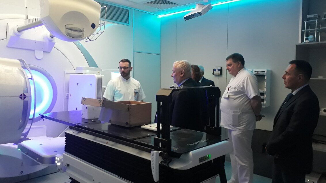 Na zdjęciu kilka osób w pracowni, w której znajduje się skaner MRI.