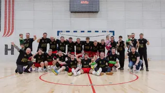 A team of handball players posing for a photo in the AGH Univeristy sports hall.