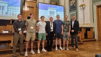 Grupowe zdjęcie: członkowie wyróżnionego zespołu, Rektor AGH, przedstawiciel organizatorów. Zdjęcie wykonane w auli AGH.