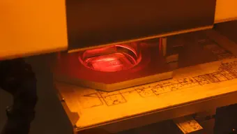 Zdjęcie wykonane w dużym zbliżeniu przedstawia proces druku płytki. 