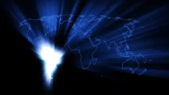 A digital world map with a radiant light shining from South America. The map is outlined in blue against a dark background.