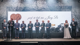 Na zdjęciu moment wręczenia medalu podczas uroczystej gali. Na scenie Rektor AGH oraz troje reprezentantów Sejmiku Województwa Małopolskiego.