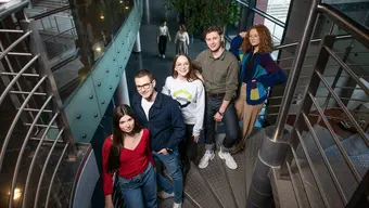 Na zdjęciu pięcioro młodych osób stoi obok siebie na krętych schodach. Zdjęcie wykonane w budynku na kampusie AGH.