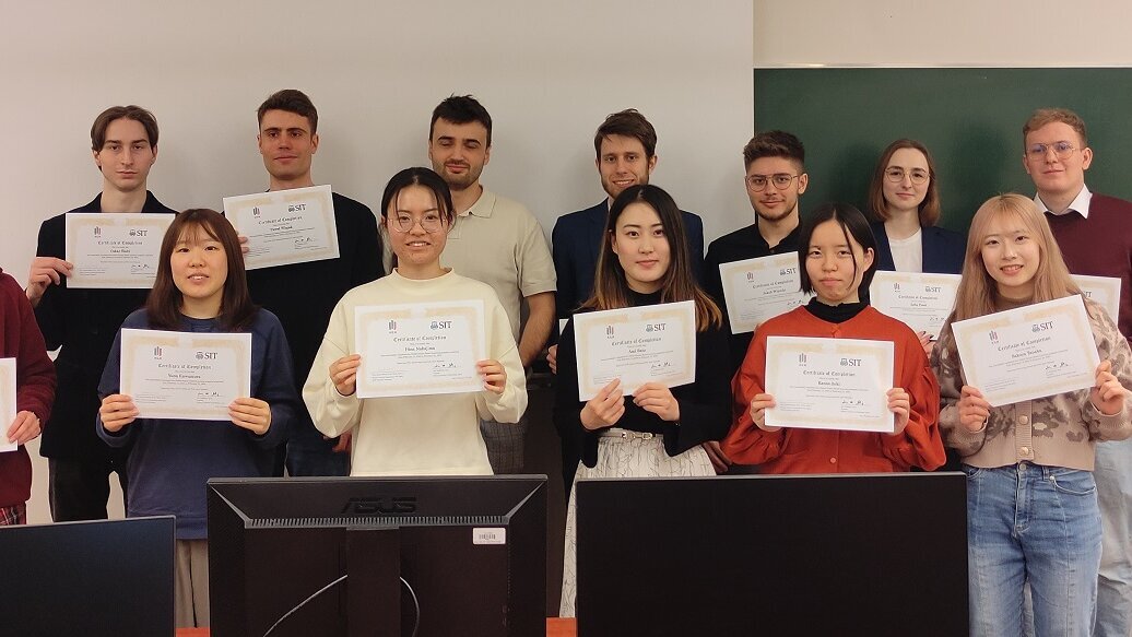 Image of participants of the Winter School of Energy Engineering standing in a classroom holding diplomas