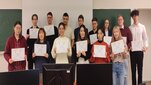Image of participants of the Winter School of Energy Engineering standing in a classroom holding diplomas