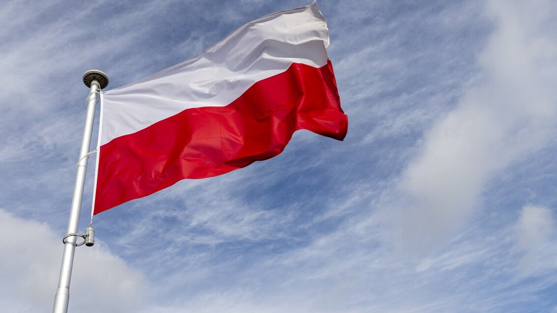 image of a cloudy sky with a white and red Polish flag