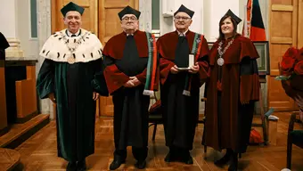 Na zdjęciu Profesorowie Honorowi AGH w togach; na ich lewych ramionach - epitogia. Obok Profesorów Honorowych stoją: Rektor AGH (po lewej) i Dziekan WIMiIP. Zdjęcie wykonane w auli AGH. 