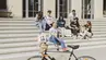 Students showcasing AGH University apparel and accessories on steps outside a university building.
