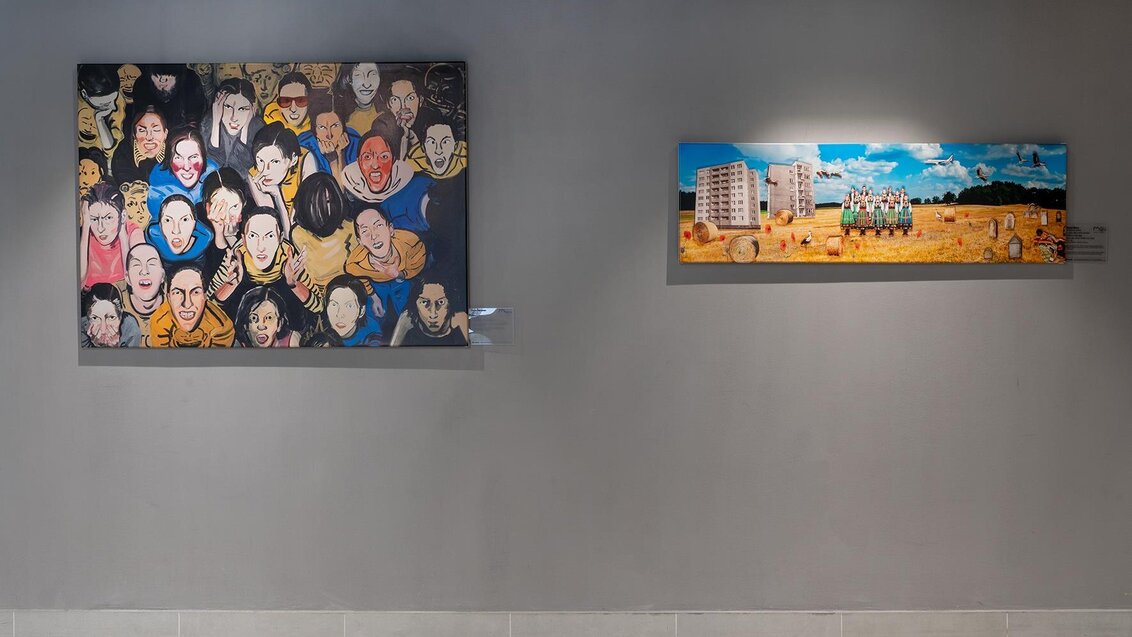 Zdjęcie dwóch obrazów wiszących na ścianie w przestrzeni uczelnianego korytarza.