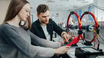 Image of two students working on an engineering project in a laboratory setting