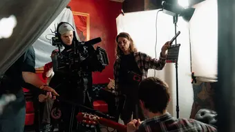 Na zdjęciu kulisy kręcenia filmu, tzw. backstage. Widoczni m.in. operator, dźwiękowiec i klapser przy pracy.