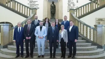 Image of AGH University authorities and representatives of Euvic Solutions standing at the main staircase of the main AGH University building