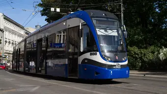 Image of a blue tramway on one of the main streets in Krakow