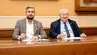 Dwóch mężczyzn siedzących przy stole w sali konferencyjnej