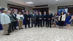 The photo shows the delegation at the Dominican Ministry of Energy and Mines. A group of elegantly dressed people in a semicircle posing for a photo.