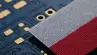 Polish flag ribbon positioned on an electronic circuit board.