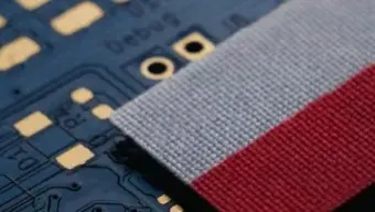 Polish flag ribbon positioned on an electronic circuit board.