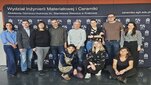 A group photograph of people in casual attire in front of a faculty backdrop.