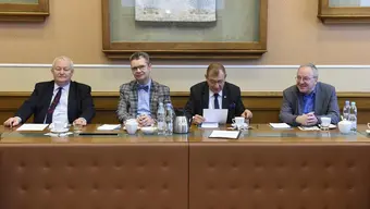 Image of four represenatives of university authorities sitting at a table with folders