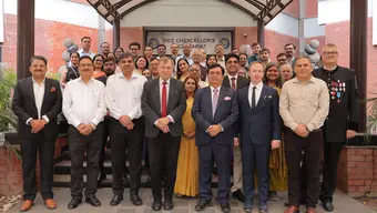 Grupowe zdjęcie delegacji AGH z reprezentacją gospodarzy przed wejściem do budynku