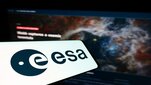 A decorative image of a phone screen with the ESA's logo in pront of a background with a photo of space