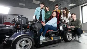 Image of a group of students next to a vehicle inside the Student Contruction Centre