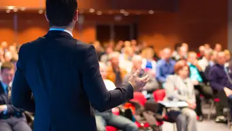 Image of an elegant man speaking to an audience
