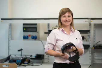 Na zdjęciu usmiechniąta Daria Hemmerling w laboratorium. W rękach trzyma google VR.