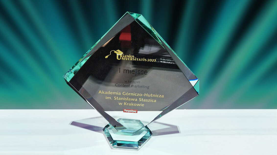 Zdjęcie szklanej statuetki w kształcie rombu. Na jednym z boków zawarto informacje o zwycięstwie AGH w konkursie. 