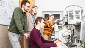 Na zdjęciu dwóch studentów i dwie studentki w specjalistycznym laboratorium.