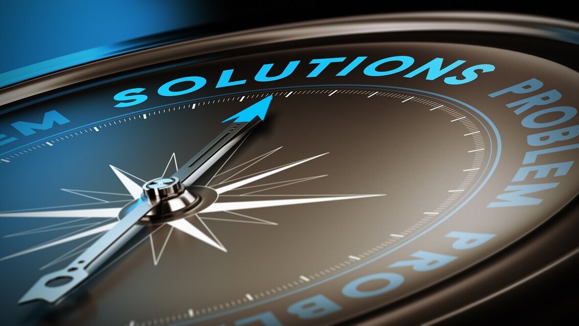 Kolorowa grafika ilustracyjna przedstawiająca strzałkę kompasu skierowaną na słowo "solutions", umieszczone pomiędzy słowami „problem”.