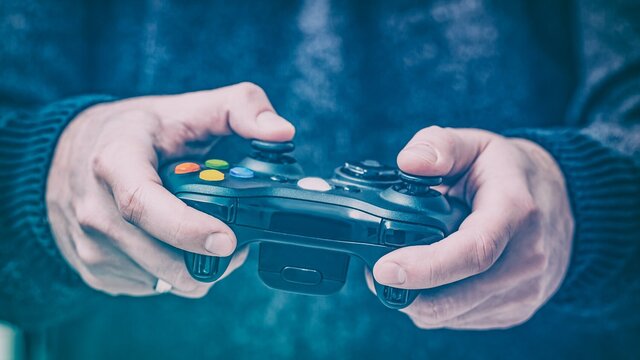 Image of two hands holding a gaming pad