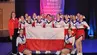 Zespół cheerleaderek reprezentujących Polskę podczas Akademickich Mistrzostw Świata w cheerleadingu prezentuje zdobyte srebrne medale i flagę Polski.