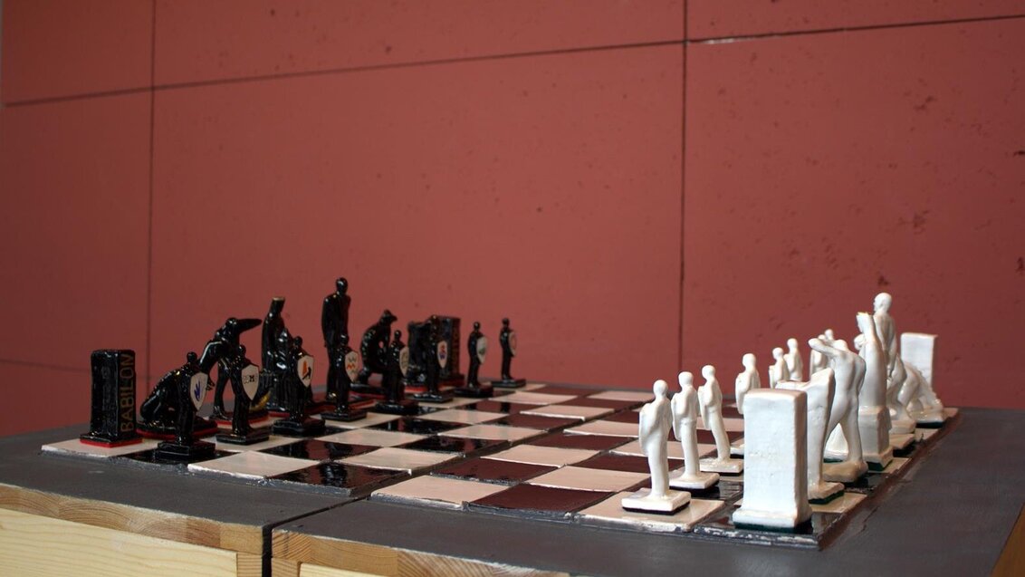 Zdjęcie ceramicznych figur szachowych na szachownicy.