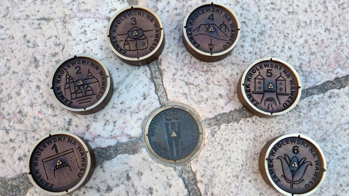 Decorative benchmarks located on a stone pavement before their final placement.