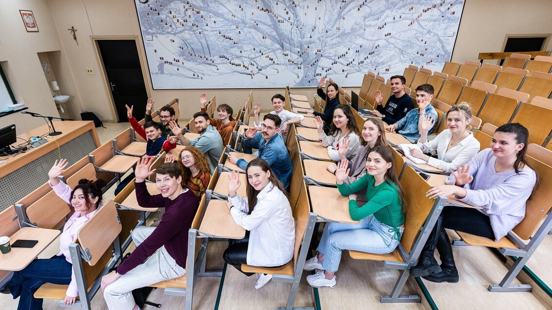 The photo shows students sitting in an auditorium.