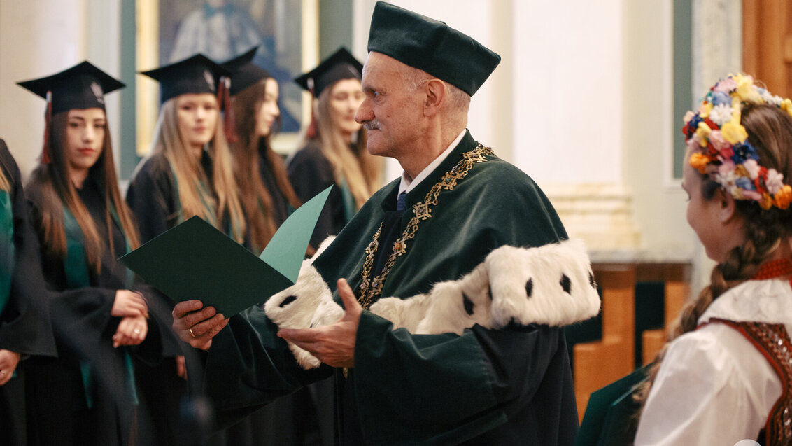 Na zdjęciu Prorektor ds. Kształcenia wręcza absolwentom dyplomy. Zdjęcie wykonane w auli AGH. 