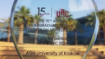 A photo of an award for the AGH University at a conference in the UAE, a glass, see-through trophy with greenery and palms seen in the background