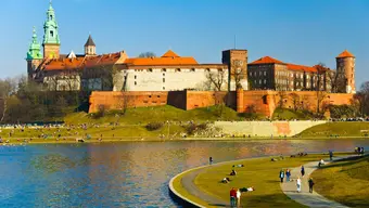 A castle located on a hill towering over a river. 