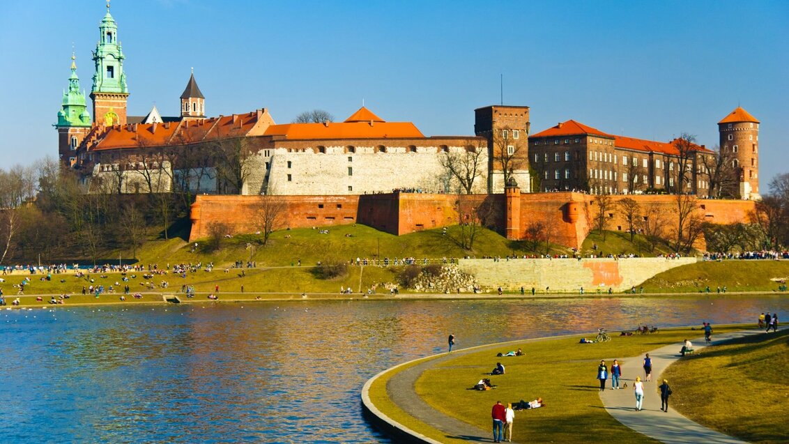 A castle located on a hill towering over a river. 