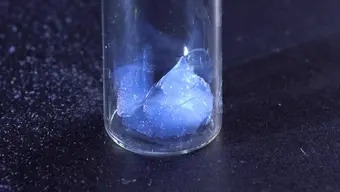 A blue aerogel in a glass container.