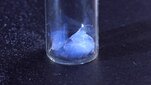 A blue aerogel in a glass container.