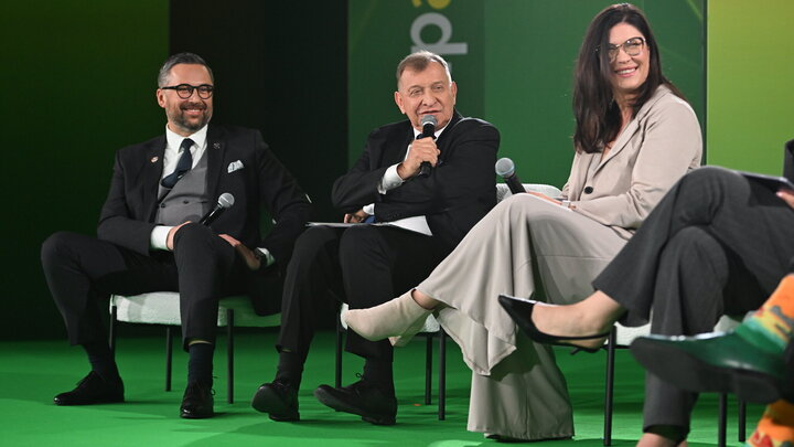 A shot of three panellists sitting on stage. 