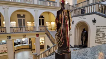 Zdjęcie pamiątkowej statuetki na tle holu reprezentacyjnego AGH